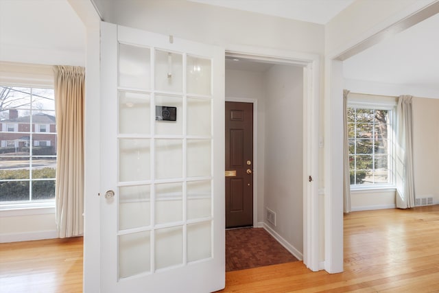 interior space featuring visible vents, light wood-type flooring, and a wealth of natural light