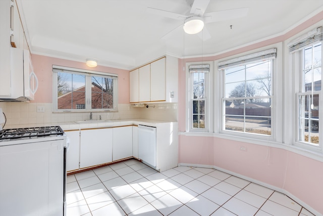 kitchen with white appliances, a sink, white cabinetry, and decorative backsplash