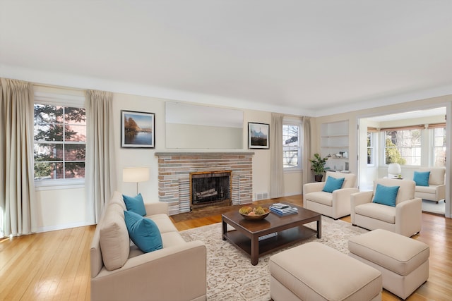 living area with light wood-type flooring and a fireplace