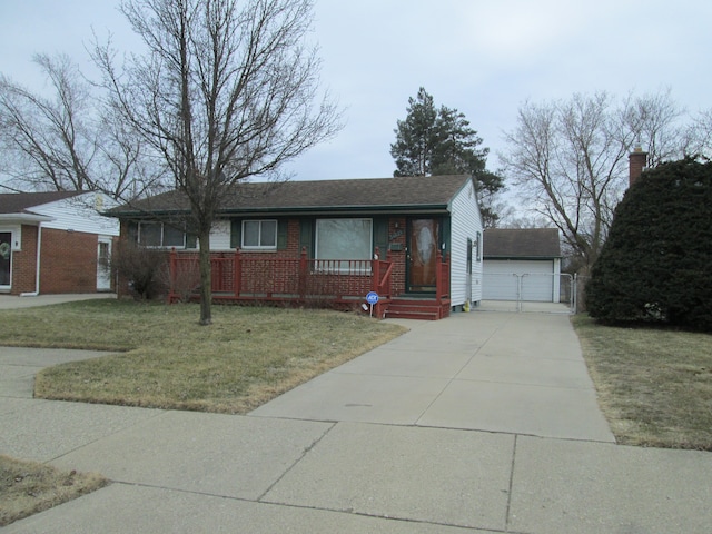 view of front of home with an outbuilding, brick siding, a porch, concrete driveway, and a front yard