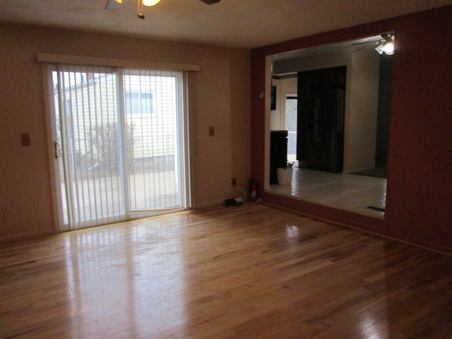 unfurnished room with wood finished floors and a ceiling fan