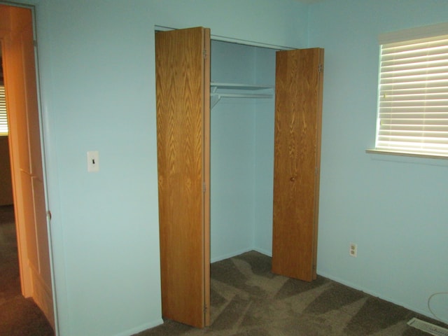 carpeted bedroom featuring a closet and visible vents