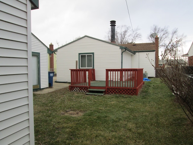 back of property featuring a lawn and a wooden deck