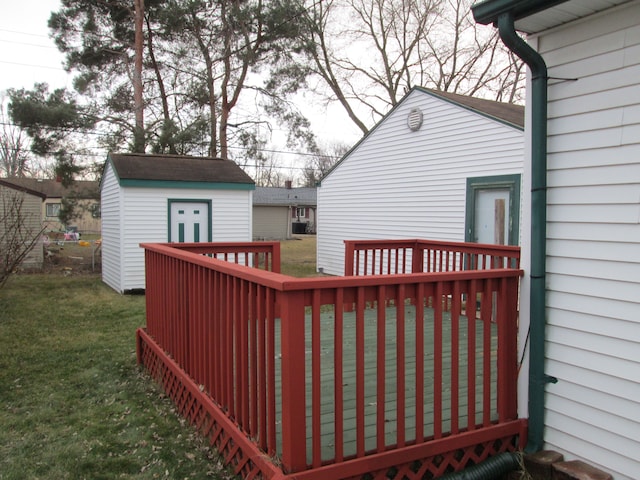 wooden deck with a yard, a shed, and an outbuilding