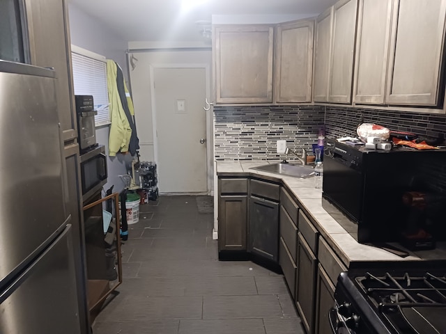 kitchen with wall oven, freestanding refrigerator, a sink, light countertops, and backsplash