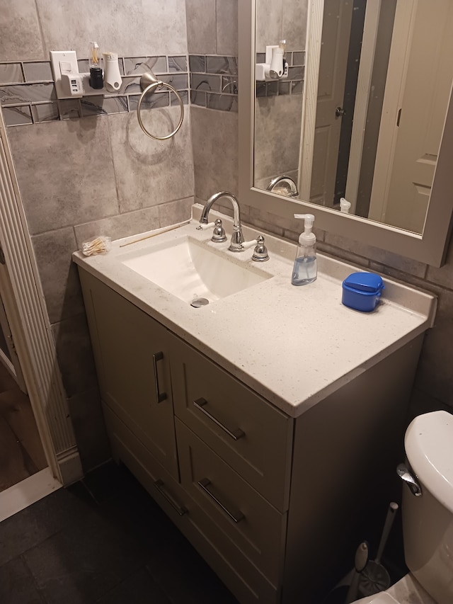 half bath featuring toilet, tile walls, and vanity