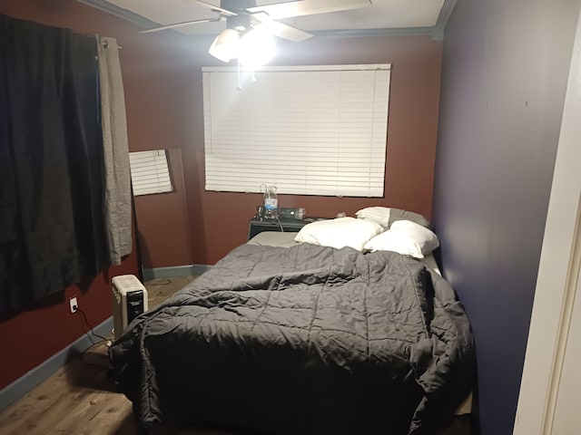 bedroom with ceiling fan, baseboards, wood finished floors, and ornamental molding