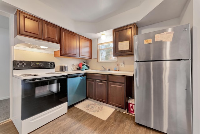 kitchen featuring range with electric stovetop, light countertops, freestanding refrigerator, under cabinet range hood, and dishwashing machine