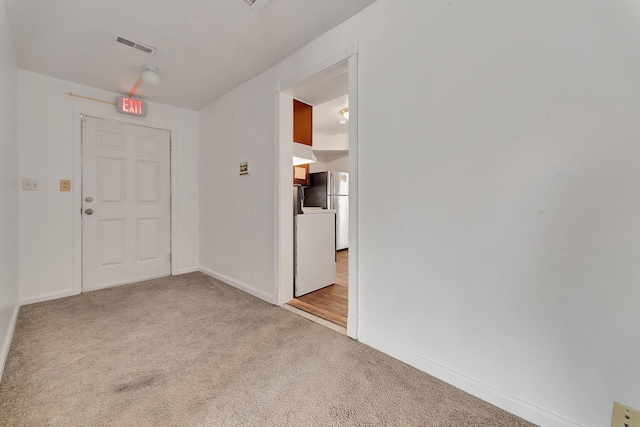 empty room with carpet flooring, visible vents, and baseboards