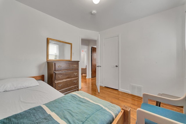 bedroom with light wood-type flooring and visible vents