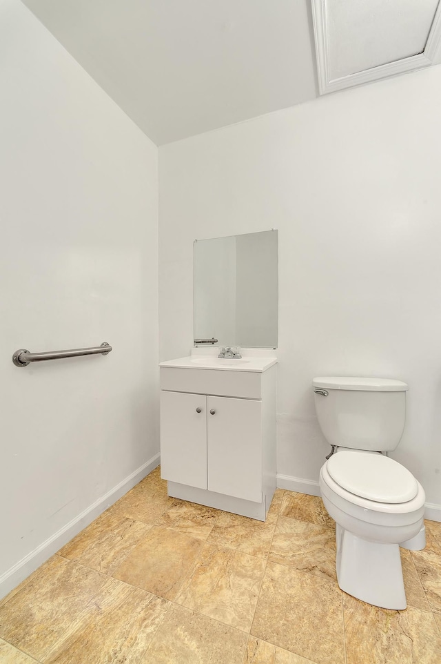 half bath featuring vanity, toilet, and baseboards