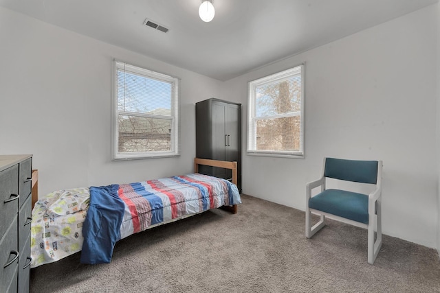 carpeted bedroom featuring visible vents