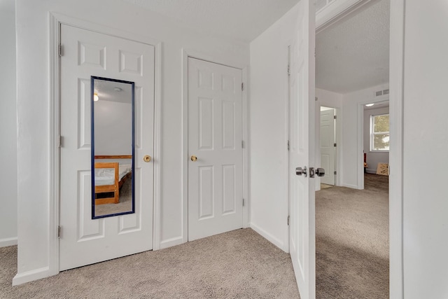 hall featuring carpet, visible vents, and baseboards