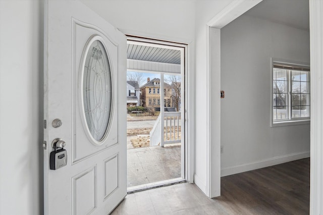 foyer entrance with baseboards and light wood-style floors