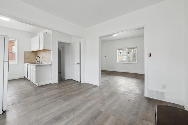 kitchen featuring a healthy amount of sunlight, visible vents, a sink, and wood finished floors