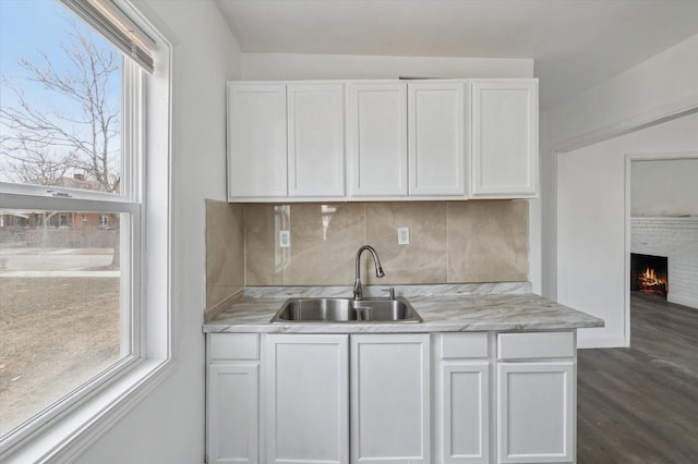 kitchen featuring plenty of natural light, a sink, and white cabinets