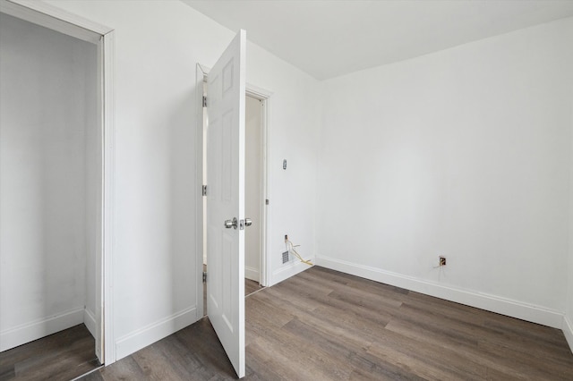 interior space with baseboards and dark wood-style flooring