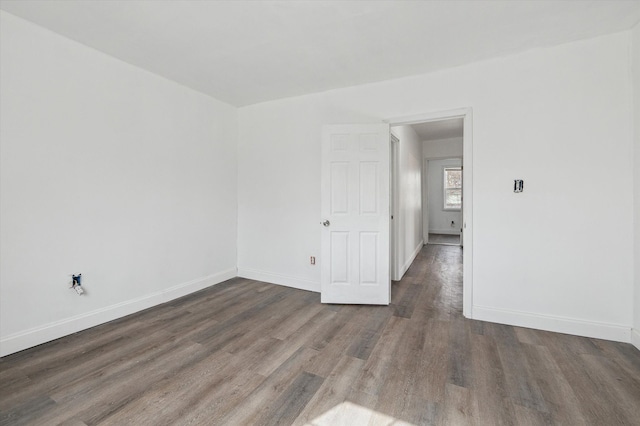 empty room with baseboards and wood finished floors