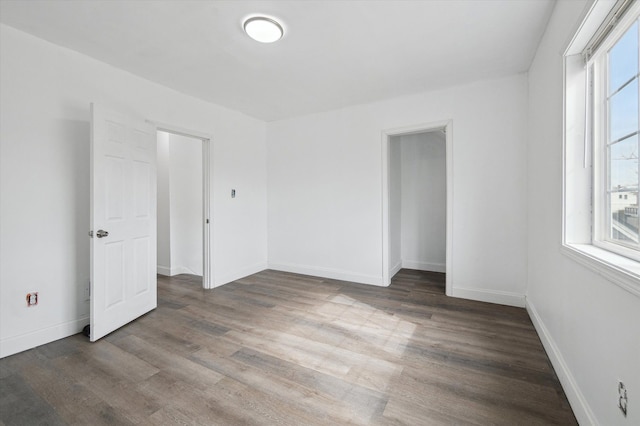 unfurnished room with baseboards and wood finished floors