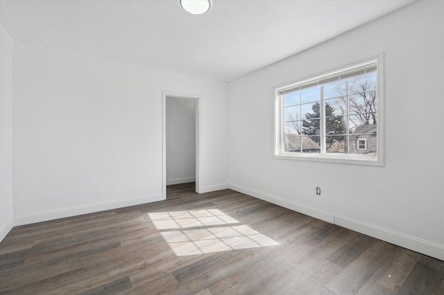 spare room featuring baseboards and wood finished floors