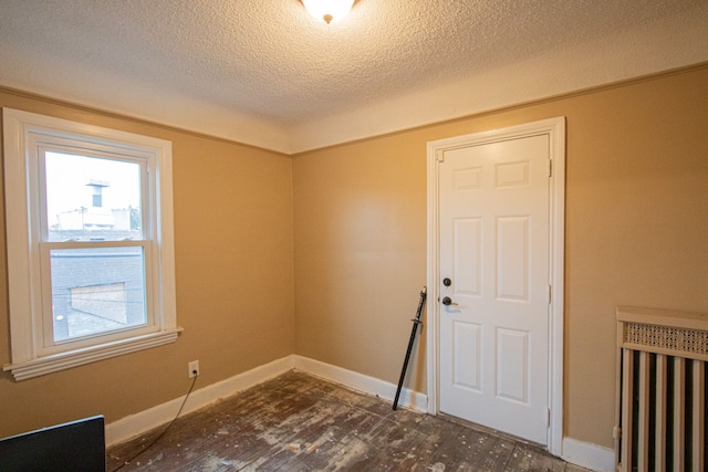 unfurnished room with baseboards and a textured ceiling