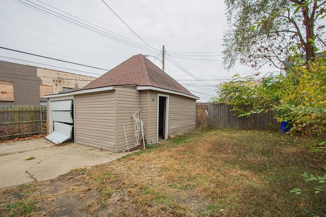 view of outdoor structure featuring fence and an outbuilding