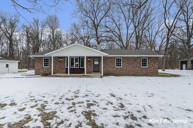 single story home with brick siding and a chimney