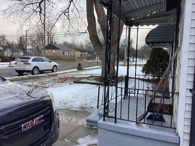 snowy yard featuring a residential view