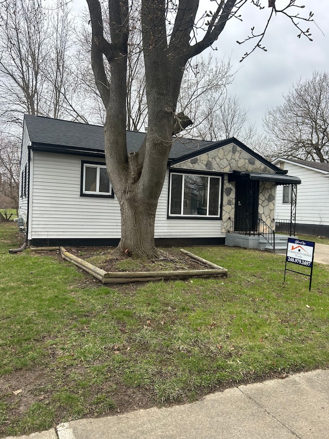 view of front of house featuring stone siding and a front lawn