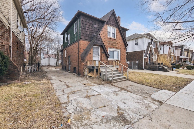 exterior space featuring a residential view, brick siding, and a chimney