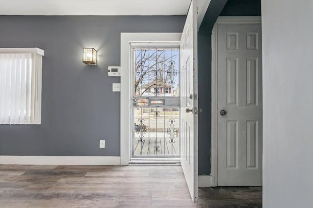 entryway featuring baseboards and wood finished floors