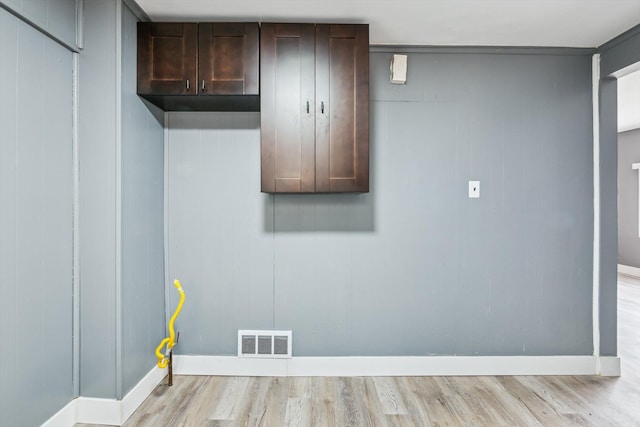 laundry room featuring visible vents, baseboards, and light wood-style floors