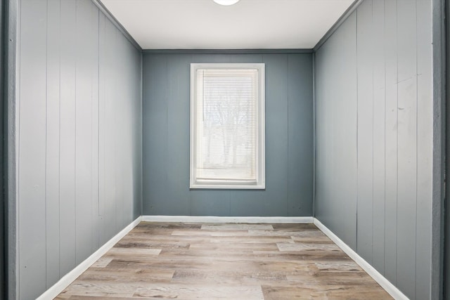 empty room featuring baseboards and light wood-style flooring