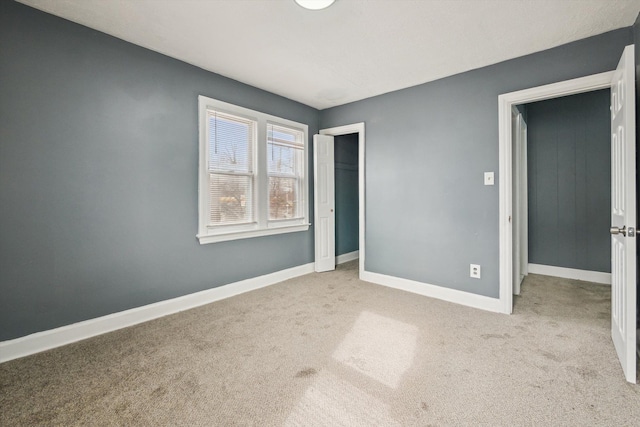 unfurnished bedroom featuring a closet, baseboards, and carpet floors