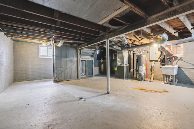 basement with heating unit, brick wall, electric panel, water heater, and a sink