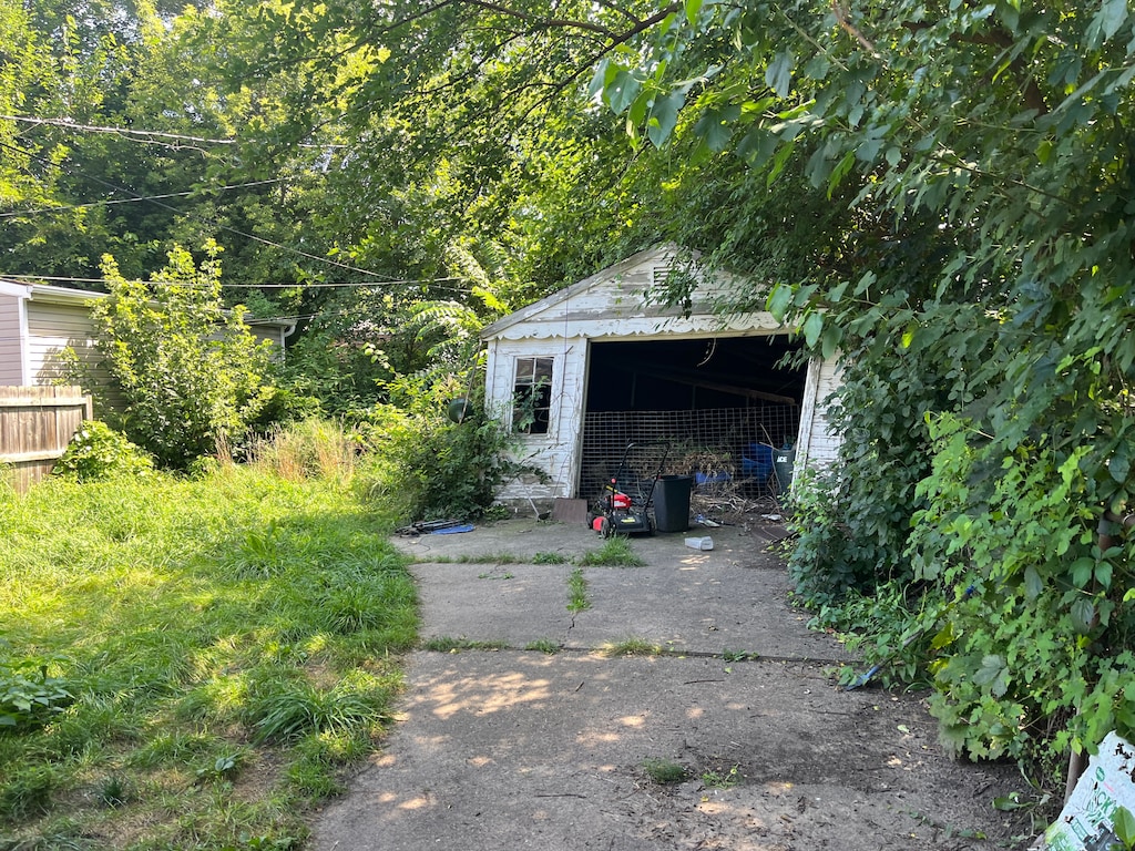 detached garage with driveway and fence