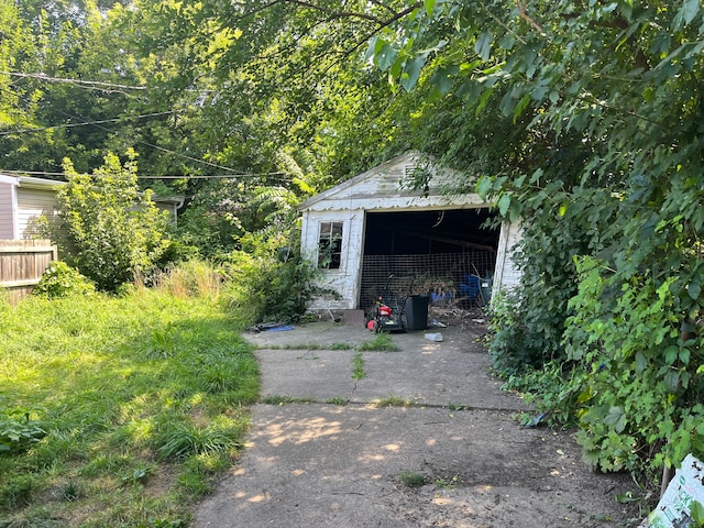 detached garage with driveway and fence