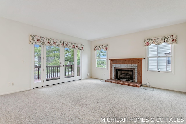 unfurnished living room with carpet floors, a tile fireplace, and baseboards