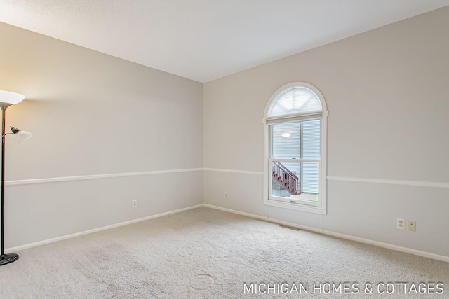 carpeted empty room featuring visible vents and baseboards