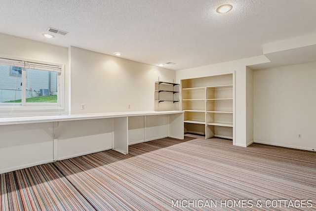 unfurnished office featuring recessed lighting, visible vents, carpet flooring, a textured ceiling, and baseboards