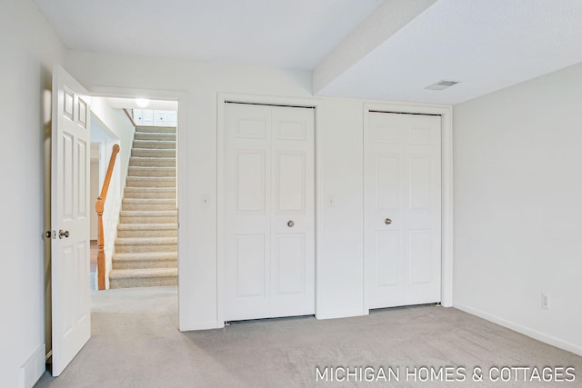 unfurnished bedroom with carpet, visible vents, and baseboards