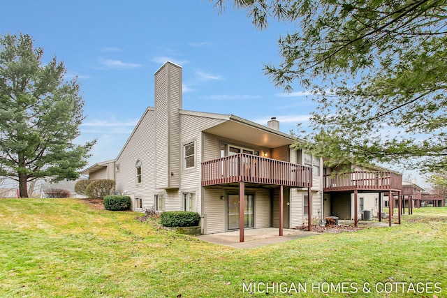 rear view of property featuring a patio, a chimney, a yard, cooling unit, and a wooden deck