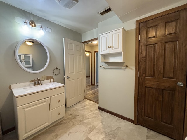 bathroom featuring vanity, visible vents, and baseboards