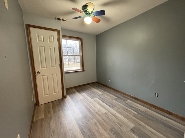 unfurnished bedroom with a ceiling fan, light wood-type flooring, visible vents, and baseboards