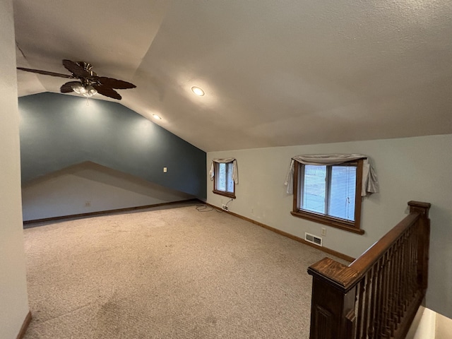 bonus room with ceiling fan, carpet floors, visible vents, baseboards, and vaulted ceiling