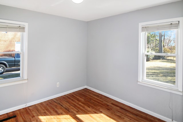 unfurnished room with visible vents, baseboards, and wood finished floors