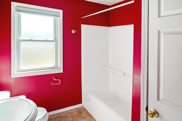 bathroom with shower / bathing tub combination, toilet, baseboards, and tile patterned floors