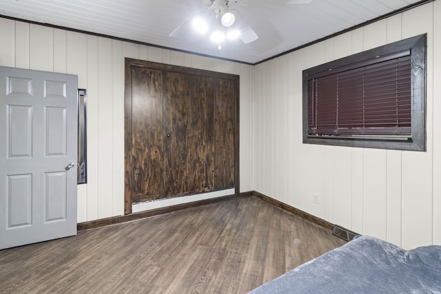 unfurnished bedroom with a ceiling fan, wood finished floors, baseboards, and a baseboard radiator