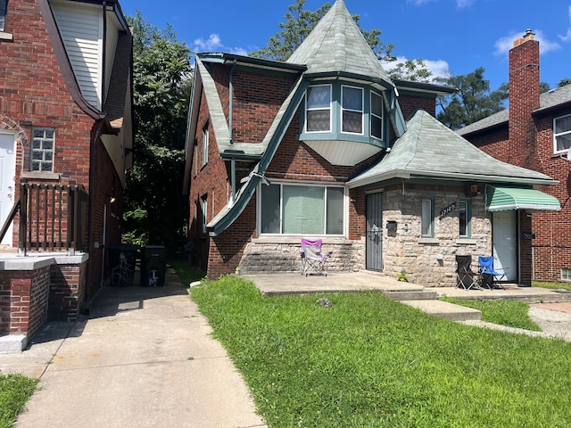 view of front of home featuring brick siding and a front lawn