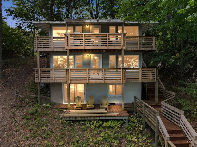 back of house featuring stairway and a wooden deck